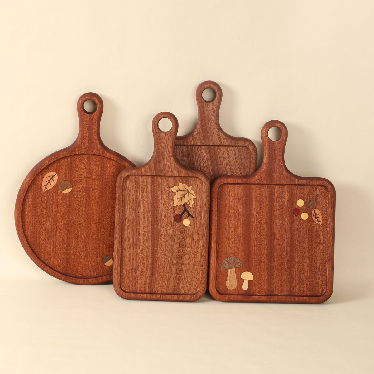 Four wooden serving boards with botanical inlay, shown together