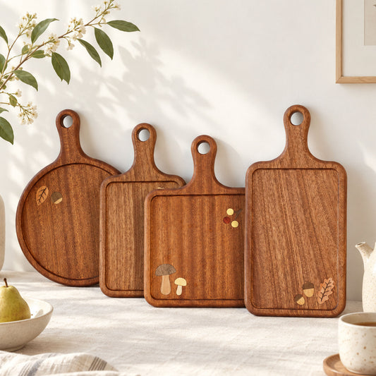 Four botanical wooden serving boards arranged on a kitchen counter