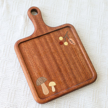 Wooden serving board with mushroom inlay detail