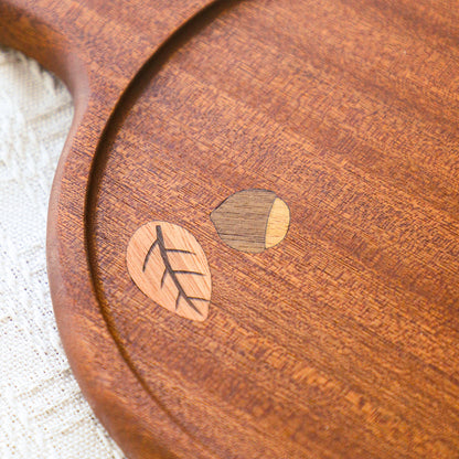 Close-up of wood grain and botanical inlay on the serving board